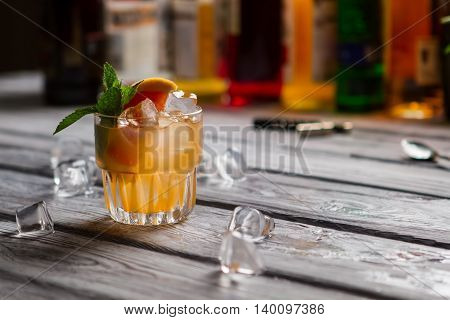 Glass with orange drink. Grapefruit slice and mint. Exotic beverage served at club. Cobas cocktail with citrus fruit.