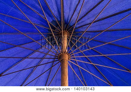 Under a long-handled blue umbrella nylon .