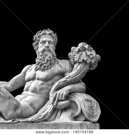 Marble statue of greek god with cornucopia in his hands isolated on black background with place for your text