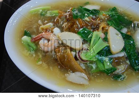 Fried wide rice noodle in gravy with mix seafood and vegetables