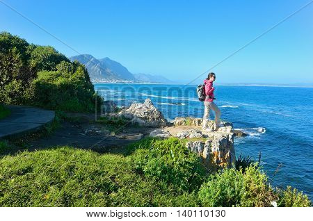 Woman looking at beautiful ocean view in Hermanus, vacation and travel in South Africa