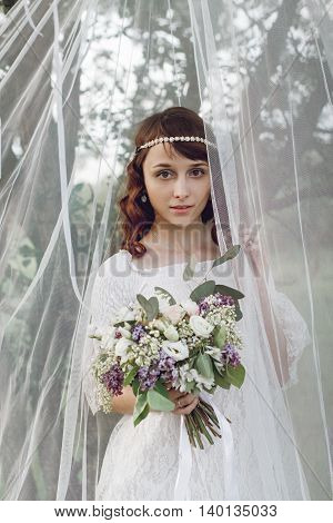 beautiful girl with bouquet of flowers in nature