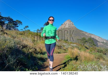 Active woman runner runs trail near Table mountain, Cape Town, South Africa. Running and fitness concept