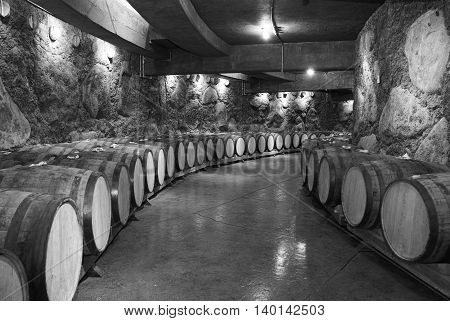 Wine barrels stacked in the old cellar of the winery.