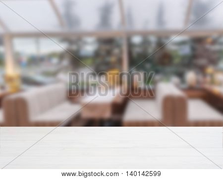 White ooden board empty table in front of blurred background. Perspective whitewood over blur in cafe interior - can be used for display or montage your products. Mockup your products