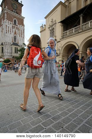 CRACOW POLAND - JULY 24 2016: Pilgrims of World Youth Day sing and dance on the Main Square in Cracow. Poland