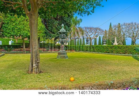 The bright orange on the grass under the tree in Bahai Garden Haifa Israel.