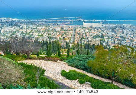 The greenery of Bahai Gardens with the city located at the Carmel Mountain foot Haifa Israel.