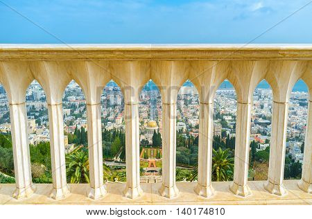The view on Bahai Gardens and Shrine through the white stone handrail on the top of Carmel Mount Haifa Israel.