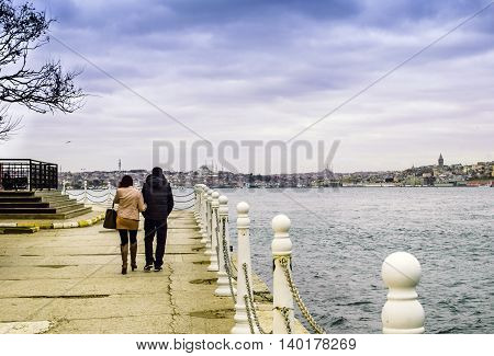 Istanbul Turkey - December 04 2013: Uskudar district a couple walking on the beach. View from the Anatolian side of Istanbul views
