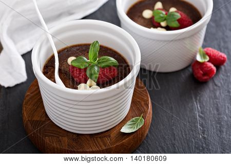 Chocolate pudding with raspberries and basil baked in ramekins
