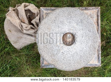 The ancient stone hand mill with grain and bag