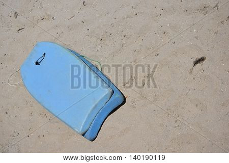 Blue Boogie Board Left on Sandy Beach