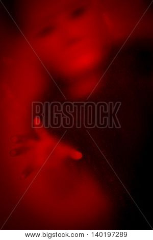 Woman wearing white mask behind stained or dirty window glass,Scary background for book cover