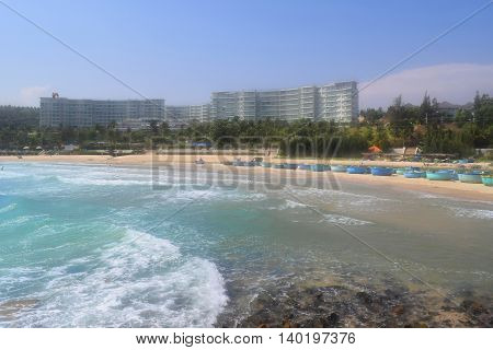 beautiful tropical beach with strong wave and building on the shore in muine vietnam