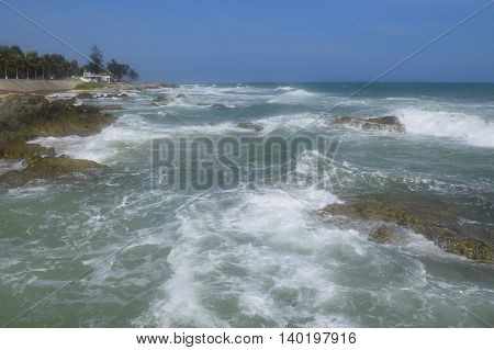beautiful tropical beach with strong wave and building on the shore in muine vietnam