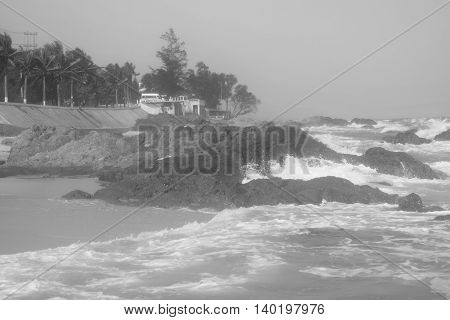 black and white tropical beach with strong wave and building on the shore in muine vietnam