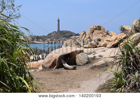 beautiful tropical beach with many rocks and historic lighthouse on small island in ke ga near muine vietnam