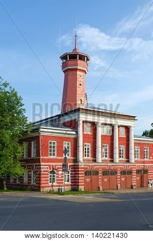 UGLICH RUSSIA - JULY 19 2016: Unknown people walk down street near building of fire department with watchtower. Building was built in years 1809-1811 on standard project. Project author Luigi Rusca