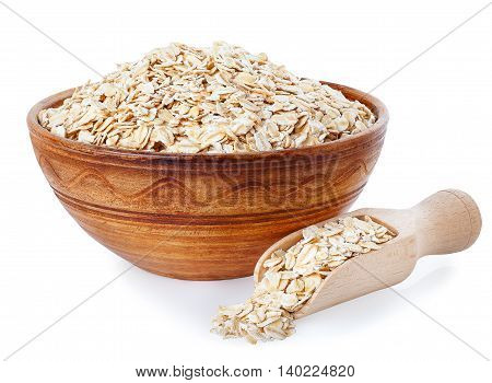 Oat flakes in clay bowl and wooden scoop isolated on a white background. Healthy food. Healthy groats. Ceramic bowl with cereals. Oatmeal