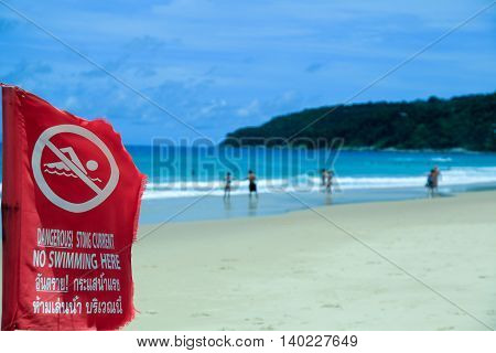 The red flag prohibiting swimming. A sea shore. Of the island.