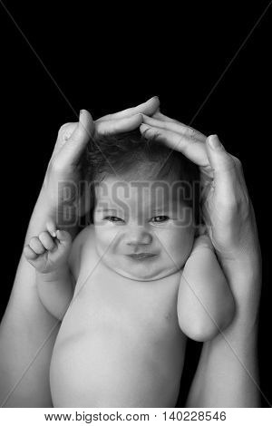 beautiful newborn baby in mother's hands. isolated on black