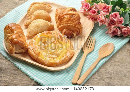 Bakery Bread on a Wooden Table. Homemade bakery on wooden dish and fabric background. Food made from flour on the wooden background.