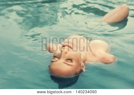 Young woman swimming in waterb tint photo