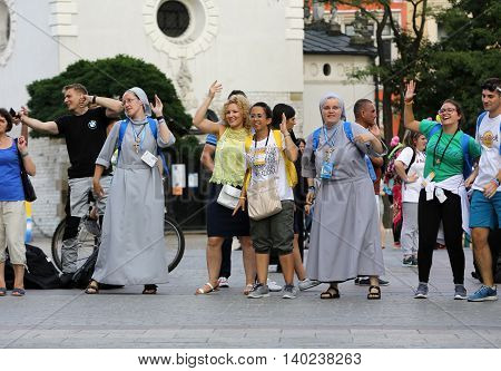 CRACOW POLAND - JULY 24 2016: Pilgrims of World Youth Day sing and dance on the Main Square in Cracow. Poland