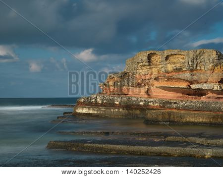 Long exposure shot on amazing pink rocks and sea