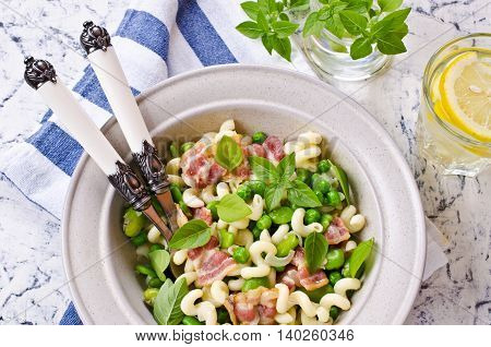 Pasta with bacon and vegetables in portion plate. Selective focus.