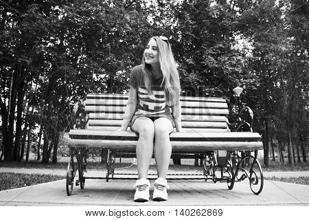 Beautiful model sits on a bench in the Park. Summer. black and white photography