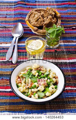 Pasta with bacon and vegetables in portion plate. Selective focus.