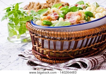 Pasta with bacon and vegetables in portion plate. Selective focus.