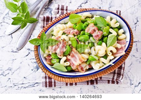Pasta with bacon and vegetables in portion plate. Selective focus.