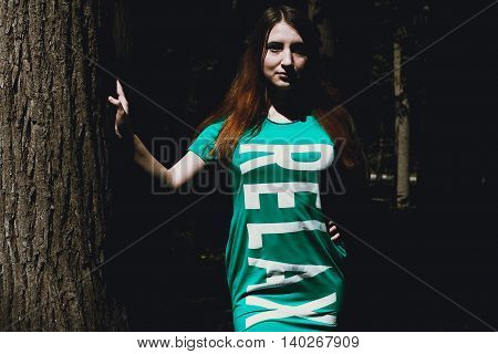 The girl and the big tree in the forest. Summer