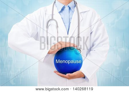 Doctor holding blue crystal ball with menopause sign on medical background.