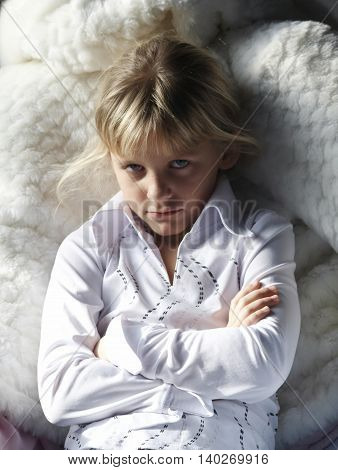 Girl portrait with streaming hair sitting in white fur chair