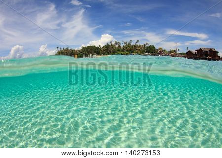 Tropical Island and sandy ocean floor. Over under half and half split photo