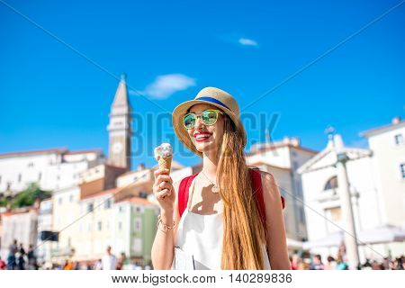 Young female traveler eating ice cream in Piran old town. Traveling in Slovenia