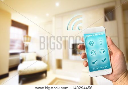 Woman hand holding smartphone against blur of living room background smart home control concept