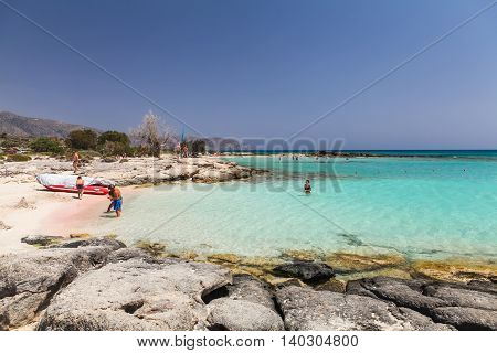 Elafonisi, Island Crete, Greece, - June 26, 2016: The lagoon of beautiful beach of Elafonisi with pink sand, boat and peopleMediterranean Sea)