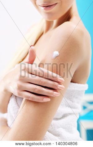 Creaming body after bathing. The woman rubbed into the skin lotion
