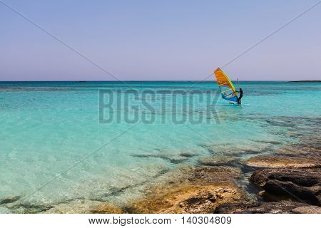 Elafonisi, Island Crete, Greece, - June 26, 2016: The windsurfers is moving in the Libyan Sea ( part of the Mediterranean Sea) on the beautiful beach of Elafonisi with pink sand.beautiful beach of Elafonisi with pink sand.