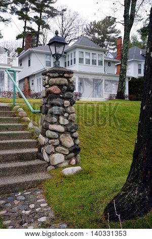 WEQUETONSING, MICHIGAN / UNITED STATES - DECEMBER 22, 2015:  A stone lamppost stands at the end of a cement stairway in Wequetonsing, Michigan.