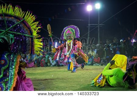 BAMNIA PURULIA WEST BENGAL INDIA - DECEMBER 23RD 2015 : Dancer dressed as Hanumanji is jumping on air Chhau Dance festival. It is a very popular Indian tribal martial dance performed at night amongst spectators.
