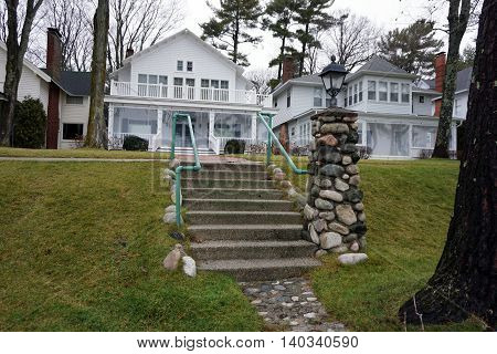 WEQUETONSING, MICHIGAN / UNITED STATES - DECEMBER 22, 2015:  A stone lamppost stands at the end of a cement stairway in Wequetonsing, Michigan.