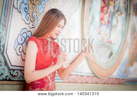 The Asian Chinese Woman In Traditional Chinese And Hold Tablel Computer