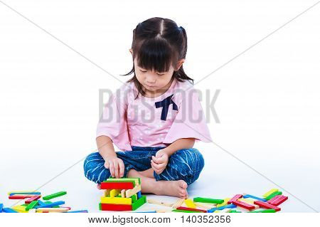 Happy asian child. Pretty girl playing toy wood blocks isolated on white background. Educational toys for kindergarten child. Strengthen the imagination of child. Studio shot.