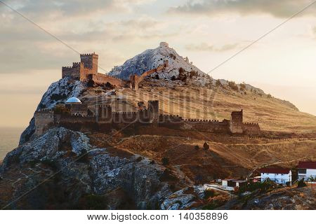 Ancient Genoese fortress in Sudak town. Panorama view at sunset. Crimea Russia.